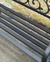 Close up of intricate seat detail on black cast iron outdoor bench Close up of intricate seat detail on black cast iron outdoor bench