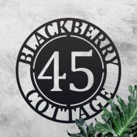 Circular Iron House Name Sign on a Rustic Finish Wall