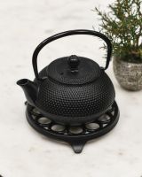 Example of Circular "Spotted" Cast Iron Trivet in Black in Use Example of Circular "Spotted" Cast Iron Trivet in Black in Use