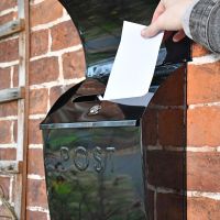 "Cityscape" Black Contemporary Post Box With Lock and Newspaper Holder in Use