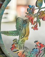 Close up of colourful rustic hummingbird detail on garden wall art