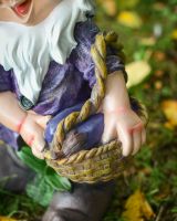 Close up of basket of veg detail on colourful garden gnome sculpture