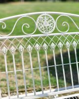 Close up of ornate scrollwork on garden swing seat