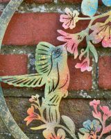 Close up of colourful steel bird detail on garden wall art