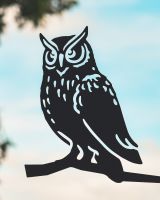 Close up of intricate cut out detail on black owl tree spike Close up of intricate cut out detail on black owl tree spike