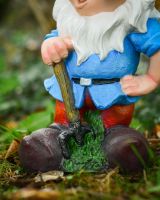 Close up of gardening tool on colourful outdoor gnome sculpture Close up of gardening tool on colourful outdoor gnome sculpture