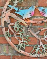 Close up of rustic branch detail on colourful garden wall art Close up of rustic branch detail on colourful garden wall art