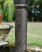 Close up of brushed gold finish on garden sundial column