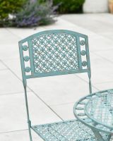 Close up of ornate chair backrest detail on patio furniture set