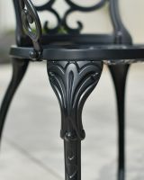 Close up of ornate chair leg detailing on two seater garden table and chairs set