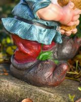 Close up of intricate detail on clothes and shoes on colourful garden gnome sculpture