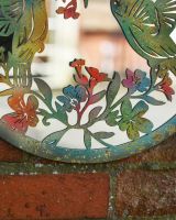 Close up of multicoloured steel wall art detail on garden mirror
