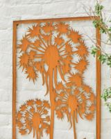 Close up of intricate dandelion cut out detail on rustic garden wall art Close up of intricate dandelion cut out detail on rustic garden wall art