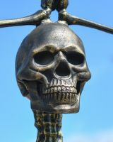 Close up of intricate brushed gold skull on skeleton garden statue