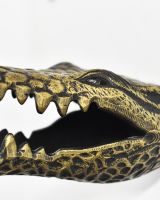 Close up of intricate face detail on gold animal wall bust Close up of intricate face detail on gold animal wall bust