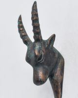 Close up of intricate gazelle head detail on verdigris coat hook Close up of intricate gazelle head detail on verdigris coat hook