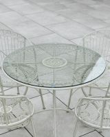 Close up of glass table top detail on four seater outdoor table and chairs set Close up of glass table top detail on four seater outdoor table and chairs set