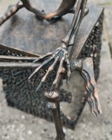 Close up of intricate hand detail on skeleton sculpture with freestanding base