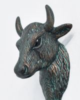 Close up of intricate verdigris face detail on coat hook Close up of intricate verdigris face detail on coat hook