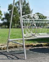 Close up of ornate scrollwork on garden two seater swing bench