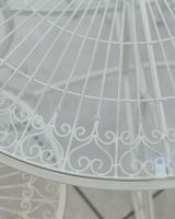 Close up of ornate detail on rustic finish white four seater outdoor dining set Close up of ornate detail on rustic finish white four seater outdoor dining set