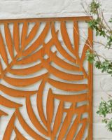 Close up of intricate palm leaf detail on rustic garden wall art Close up of intricate palm leaf detail on rustic garden wall art