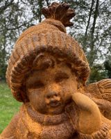 Close up of intricate face detail on young girl bundled up in winter clothes garden statue