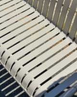 Close up of stone grey slatted seat on garden bench