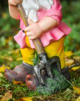 Close up of gardening tool on colourful outdoor gnome Close up of gardening tool on colourful outdoor gnome