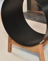 Close up of intricate curved black steel detail on modern fire place log bucket
