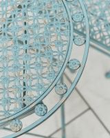 Close up of ornate detail on teal and green two seater outdoor furniture set