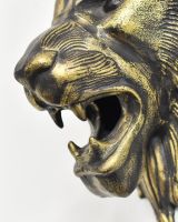 Close up of intricate teeth detail on black and gold lion head wall bust