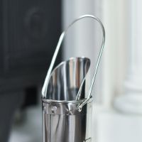 Close up of intricate steel detail on long wood burner match holder