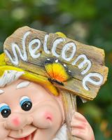 Close up of intricate detail on welcome sign on colourful garden gnome sculpture