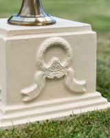Close up of wreath and ribbon detail on garden sundial column