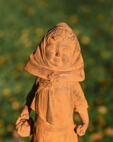 Close up of Rustic Cast Iron Girl With Basket  Close up of Rustic Cast Iron Girl With Basket
