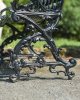 Close up of ornate side detail on black garden bench