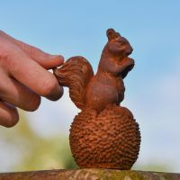 Squirrel & Chestnut Garden Sculpture with Hand for scale 