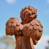 Close up of Wings on Rustic Cast Iron Angel Reading Sculpture