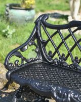 Close up of ornate arm detail on cast iron outdoor bench