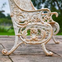 Close up of Antique Cream Bench Leg and Armrest with Scroll and Leaf detail