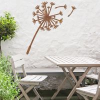 Dandelion Wall Art in the Garden Above a Wooden Table and Chair Set Dandelion Wall Art in the Garden Above a Wooden Table and Chair Set