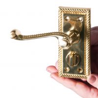 Polished brass lever handle in hand Polished brass lever handle in hand