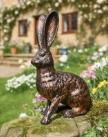 Digital illustration of a Bronze Cast Aluminium "Clover" The Sitting Rabbit Garden Sculpture in a Flowery Cottage Garden