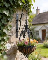 Digital illustration of "Loredale Manor" Black Ornate Hanging Basket in front of stone cottage
