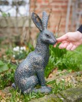 Digital illustration ofa Verdigris "Briar" the Hare Cast Aluminium Garden Sculpture with hand in shot for scale