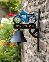 Digital illustration of Cast Iron Hand Painted Blue Motorbike Garden Bell angled view in a traditional garden