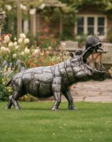 Digital Illustration of Recycled Metal Fighting Hippo Sculpture in Front of Rustic Cottage
