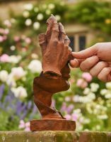 Digital illustration of Rustic Cast Iron Abstract "Thinker" Sculpture side view with hand in shot for scale