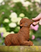 Digital illustration of Rustic Cast Iron Lying Down Lamb with hand in shot for scale